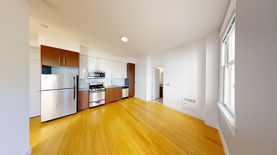 A kitchen with wooden floors and white walls.